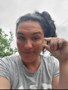 Photo of lady holding up 2 capsule of Enrich digestive enzymes