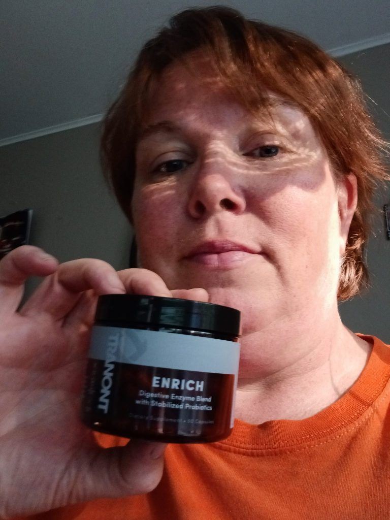 Photo of women holding up a bottle of Enirch digestive enzymes