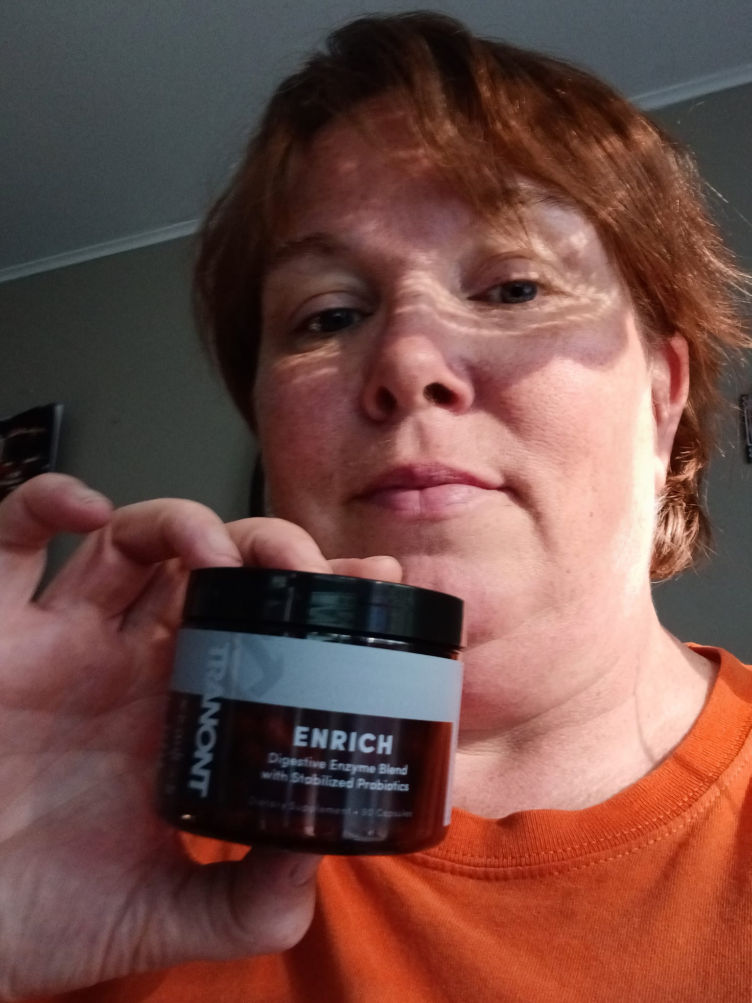 Photo of women holding up a bottle of Enirch digestive enzymes