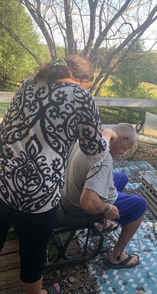 picture of a women trimming a man's hair