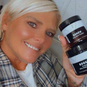 Woman holding up her favorite 2 bottles of Tranont products. Renew antioxidant complex & Boost nitric oxide