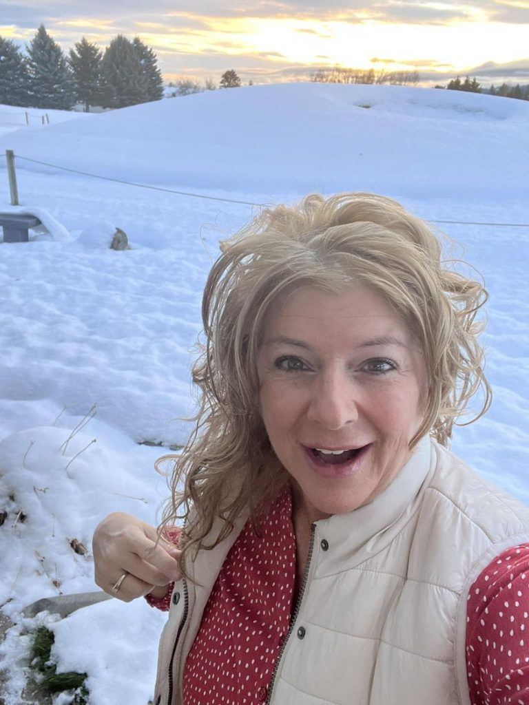 Picture of a lady standing in the snow showing off her long hair