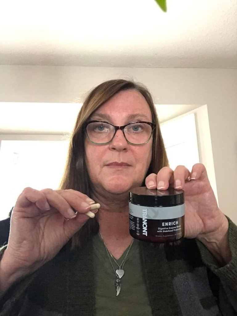 lady holding up a bottle of Enrich