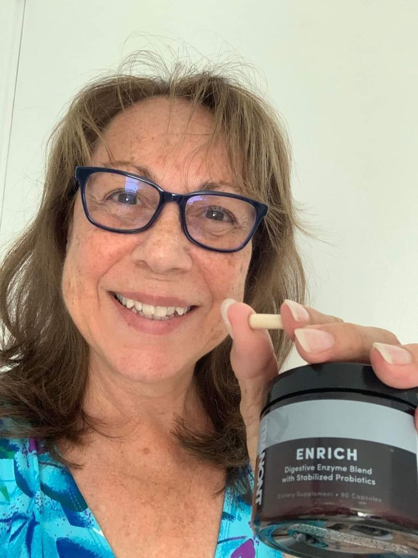 photo of women holding up a bottle of Enrich