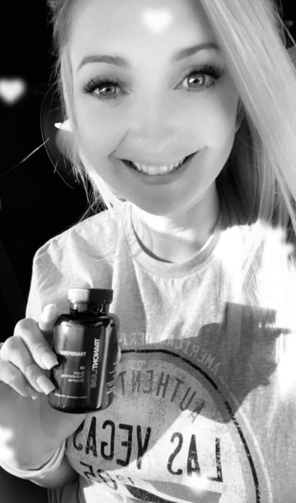a very happy lady holding a bottle of Transform
