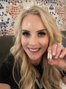 a woman holding up two capsules of Transform