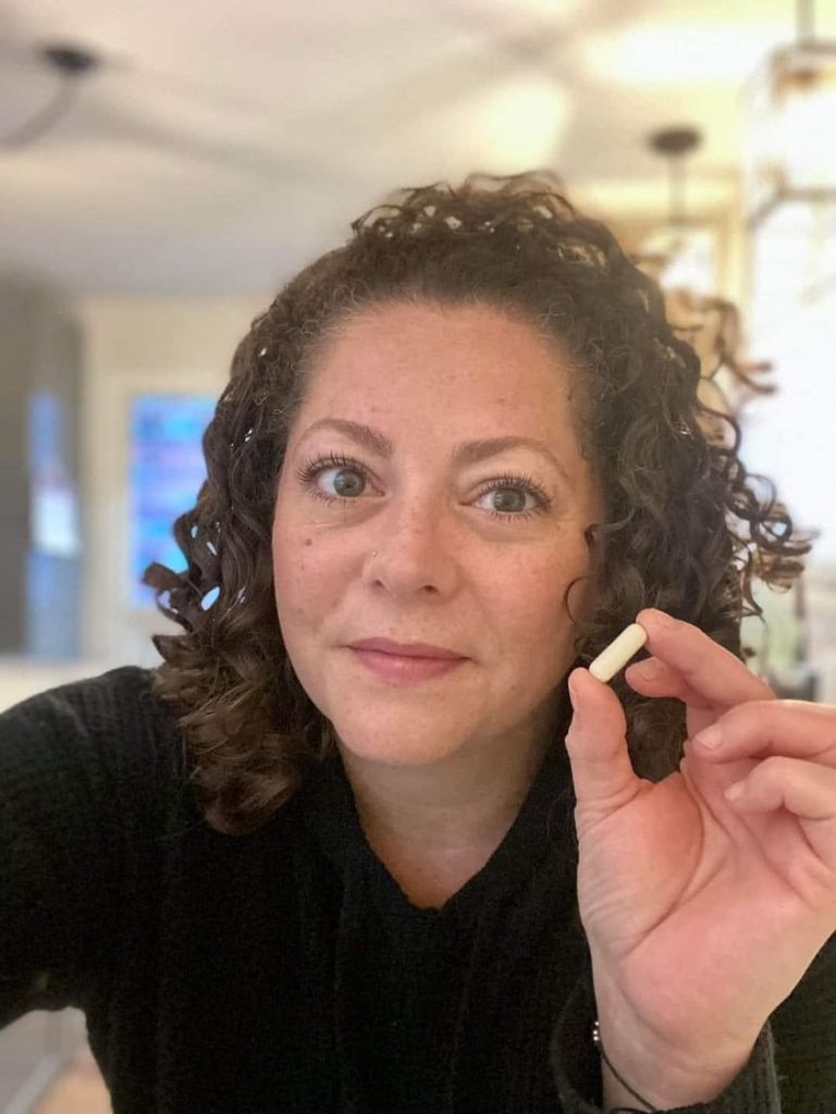 A woman holding up our plant enzyme Transform