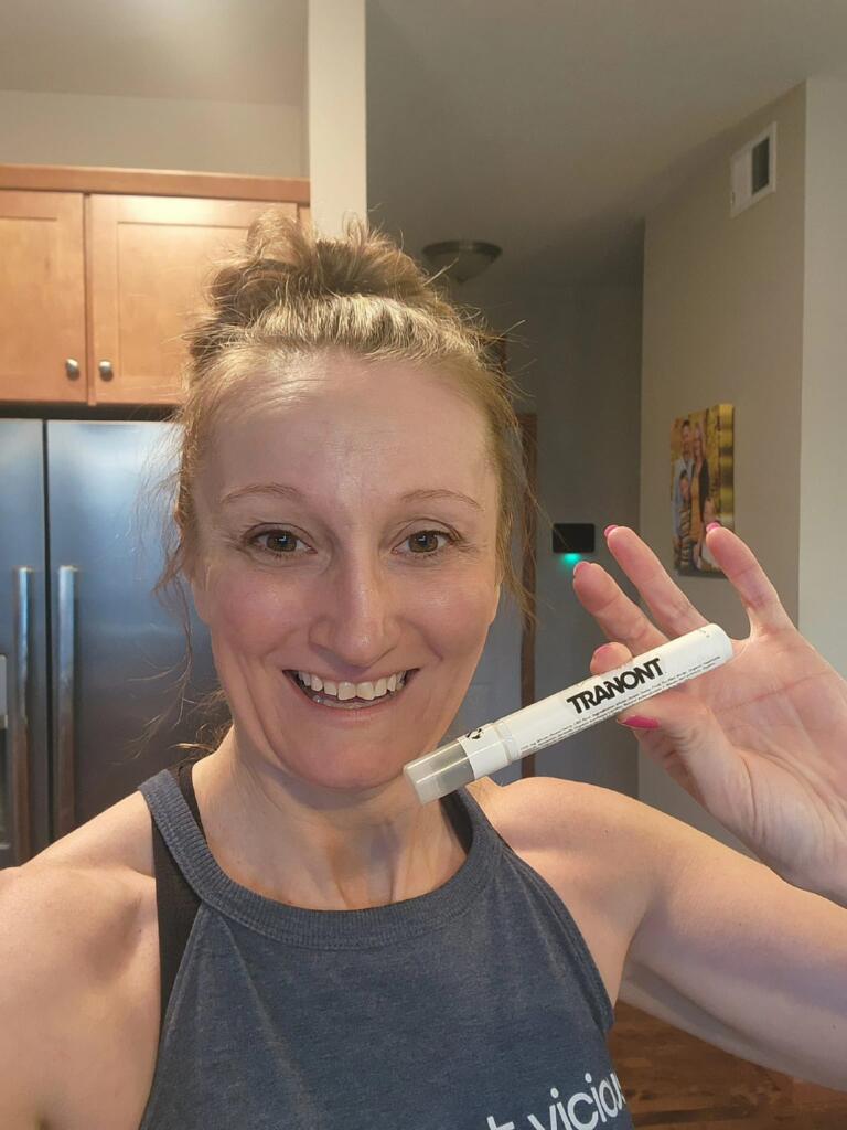 A very happy woman holding up Suthe CBD spray